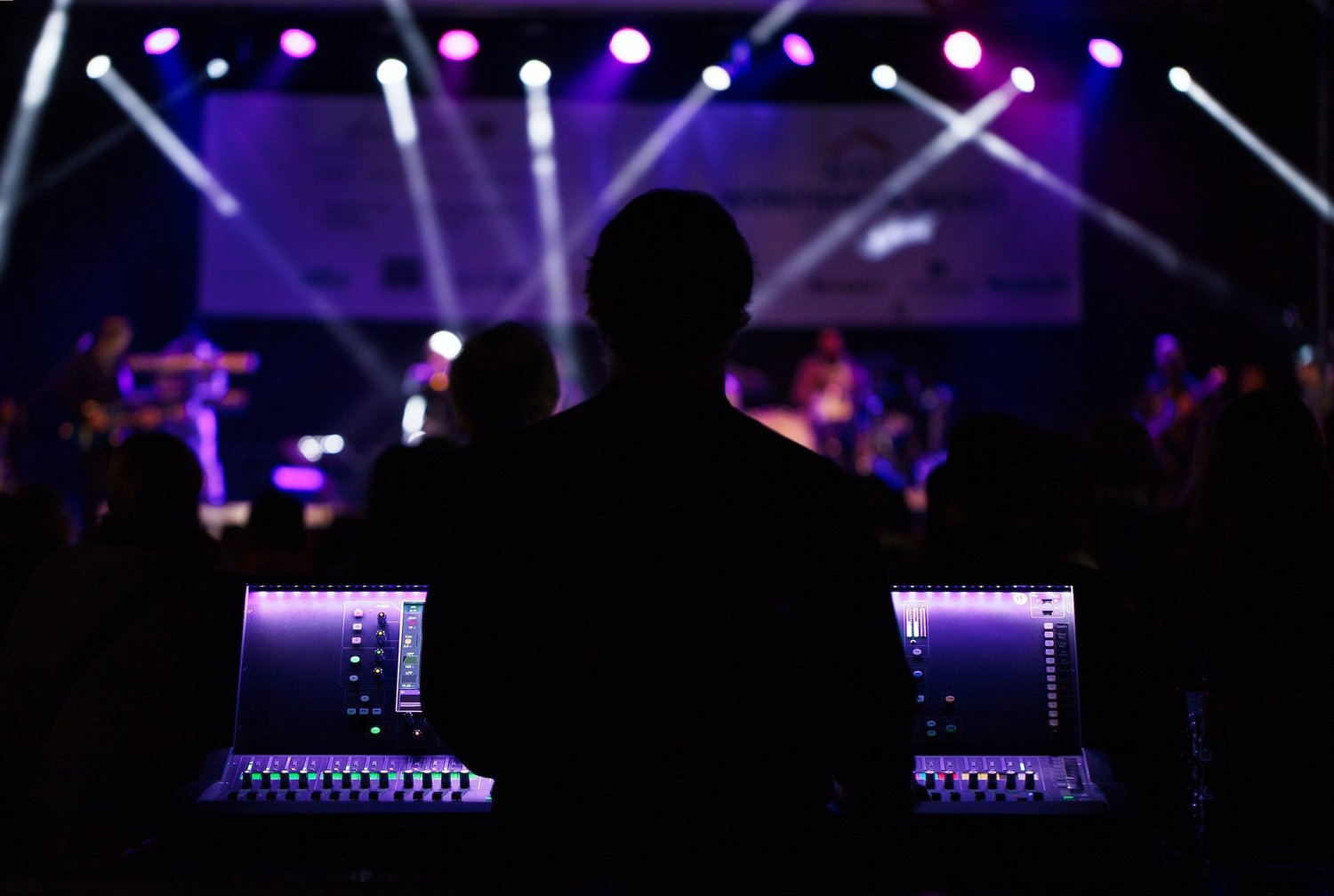 Audio engineer mixing front-of-house at a live concert
