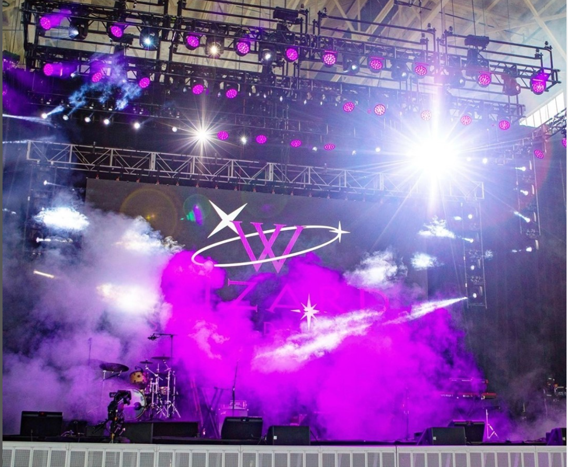Concert stage with purple lighting and atmospheric haze