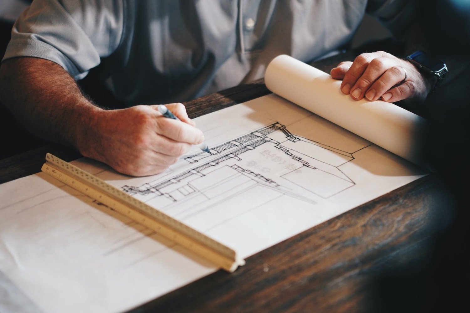 Designer drawing on architectural blueprints